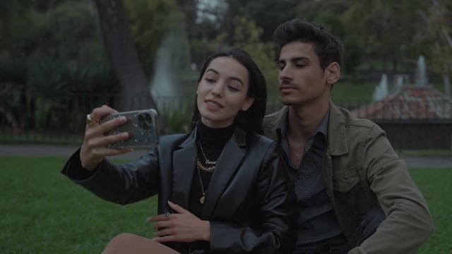 A couple taking a selfie in a park