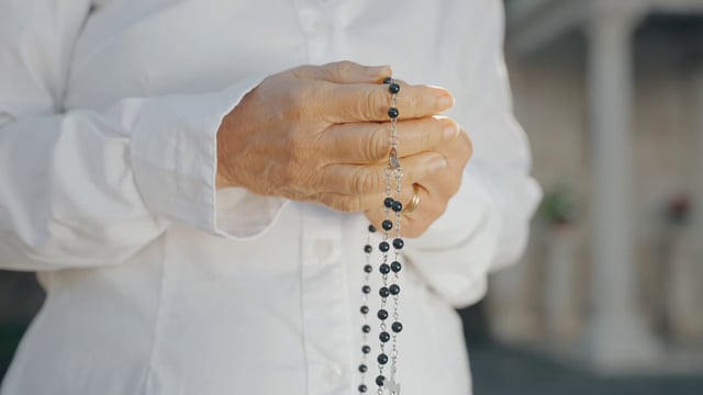 A woman holding rosary beads