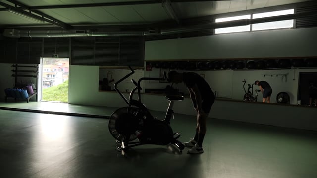 Deportista va a entrenar en la bicicleta estática