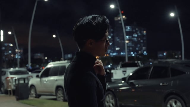 Hombre asiático se encuentra en una calle de noche