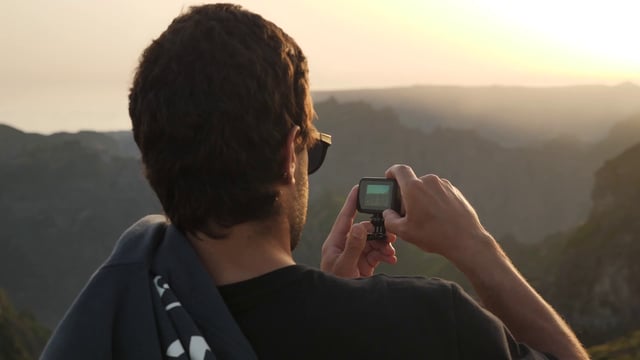 一名男子在山顶上使用GoPro