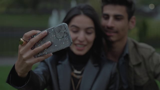 Una pareja se toma un selfie en un parque.