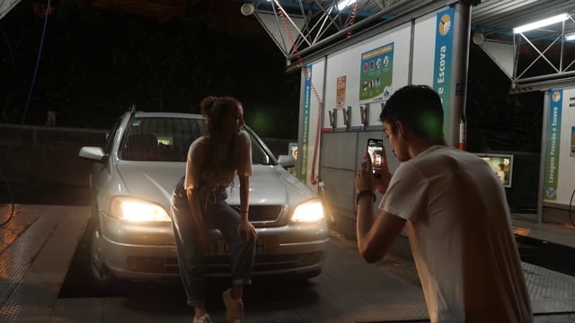 El hombre toma fotografías de la mujer en el lavado de autos
