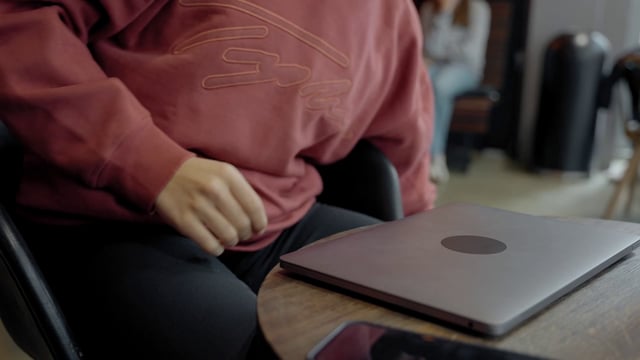 Un chico abre una computadora portátil en un café.