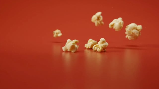 Palomitas de maíz cae sobre una mesa roja