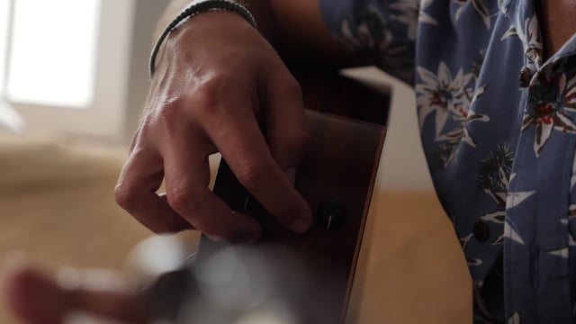 Man adjusts guitar settings
