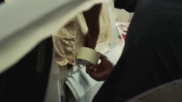 Man taping material to a car door