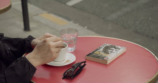 Woman drinking coffee at a Paris cafe