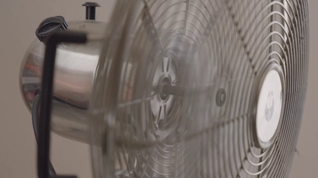 A woman turns off a fan