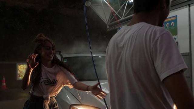 Woman spraying man with water