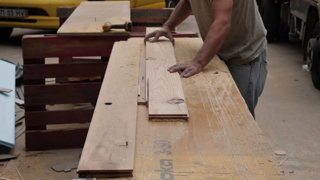 Carpenter cuts piece of wood