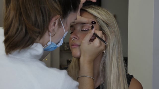 Makeup artist does eyeliner for client