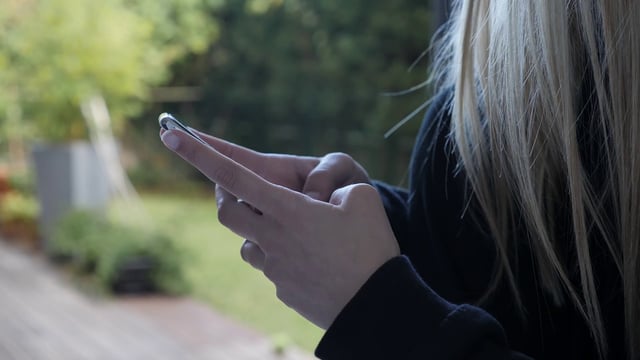 Girl using phone outdoors