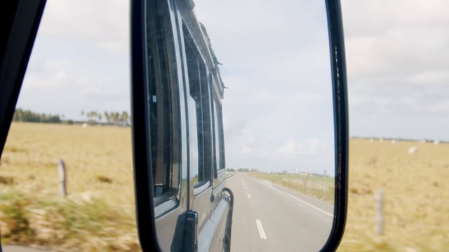 Vista en el espejo retrovisor lateral de un automóvil en movimiento