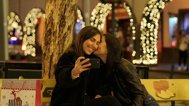 Novias hacen selfie en un cuadrado iluminado