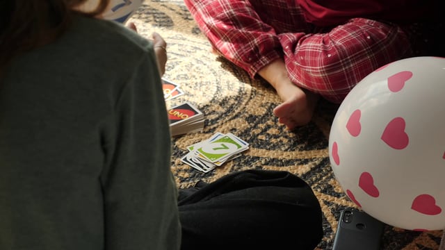 A mom wins a game of UNO against her daughter