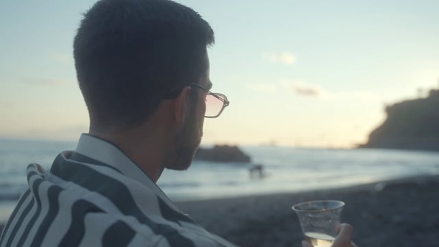 A man drinking wine at the beach