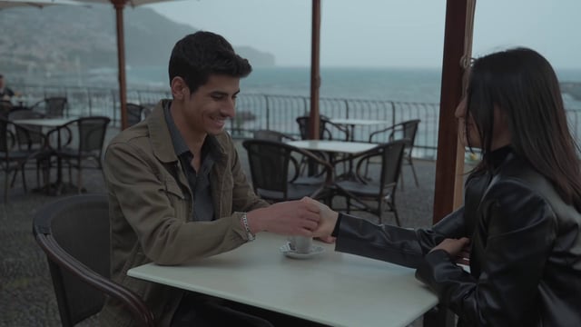 Una pareja amorosa juega un juego de dedos en un café