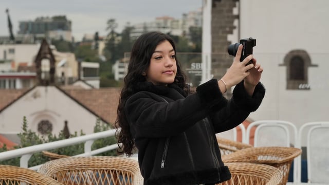 Una chica graba un vlog en la terraza de un café